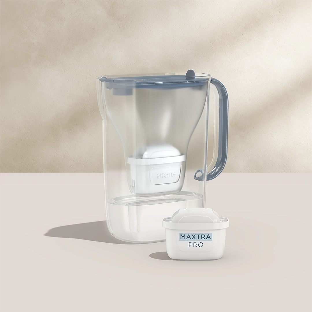 BRITA Style Essential en bleu avec une cartouche filtrante MAXTRA PRO sur fond beige.