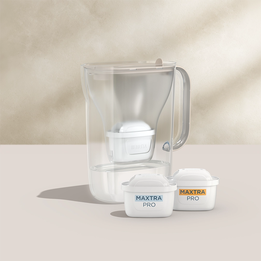 BRITA Style Essential couleur sable avec deux cartouches filtrantes MAXTRA PRO sur fond beige.
