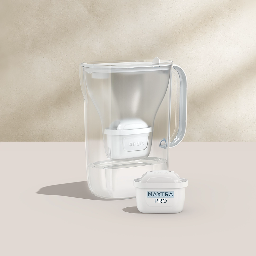 BRITA Style Essential en blanc avec une cartouche filtrante MAXTRA PRO sur fond beige.